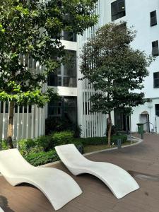 two white benches sitting in front of a building at Cozy suite-The Shore in Kota Kinabalu