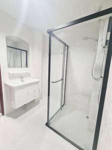 a white bathroom with a shower and a sink at Star house Seaview Lanta old town in Ko Por