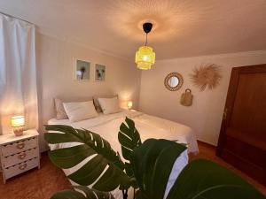 a bedroom with a bed and a potted plant at Palm Leaf Mogan in Puerto de Mogán
