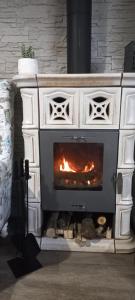 a white stone fireplace with a fire in it at Borostyánkút Wellness Home Bakonybél in Bakonybél +130 photos