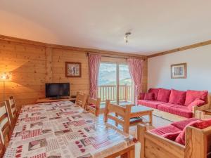 a living room with a table and a red couch at Appartement spacieux 8 pers, parking, ski aux pieds - FR-1-352-79 in Arc 1800