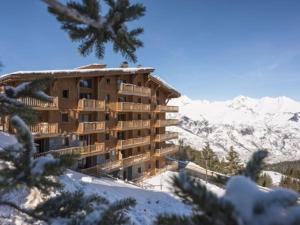 a building in the snow with snow covered mountains at Appartement spacieux 8 pers, parking, ski aux pieds - FR-1-352-79 in Arc 1800