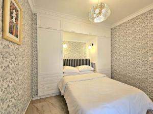 a white bedroom with two beds and a mirror at Our home Our heaven in Madinaty