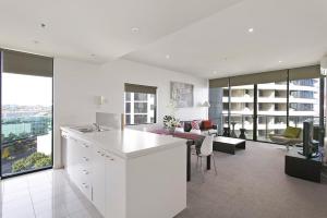 a white kitchen and living room with a view of a building at Docklands Private Collection - NEWQUAY in Melbourne