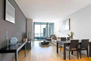 a living room with a table and chairs and a couch at Docklands Private Collection - NEWQUAY in Melbourne