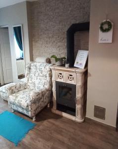 a living room with a chair and a fireplace at Borostyánkút Wellness Home Bakonybél in Bakonybél