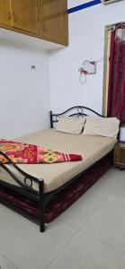 Una cama en una habitación con avertisementatronatronatronststrationstrationstrationstration en AVVAI Home Stay, en Madurai