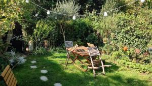 a table and two chairs in a garden at Studio au 2e étage de notre maison de ville in Caen