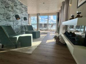 a living room with chairs and a table with a view of the ocean at Wasserhaus Schlei in Schleswig