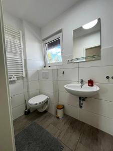 a bathroom with a sink and a toilet and a mirror at Gemütliche Wohnung nahe Messe und Flughafen in Ratingen