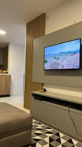a living room with a flat screen tv on a wall at Apartamento novo perto da praia e Beto Carrero in Piçarras