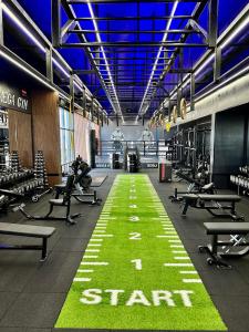 a gym with a green floor with a start sign at Вид на закат, море и бассейн in Batumi +30 photos