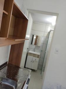 una piccola cucina con lavandino e specchio di Cantinho da Pinheira a Palhoça