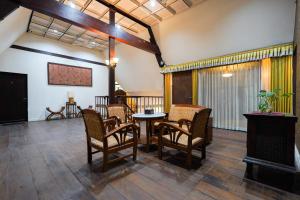 a living room with chairs and a table at Indraloka Heritage Homestay in Yogyakarta