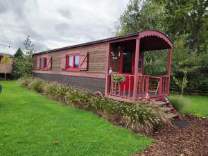 a small house with red trim in a yard at Puck B&B Babbita in Hasselt