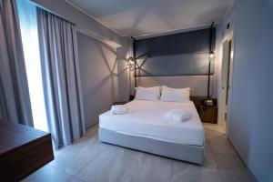 a bedroom with a large white bed with white pillows at Best Western Plus Sabaudia Hotel in Sabaudia