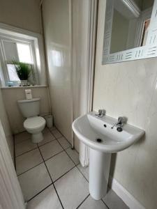 a white bathroom with a toilet and a sink at Stay at 25 in Blackpool +62 photos