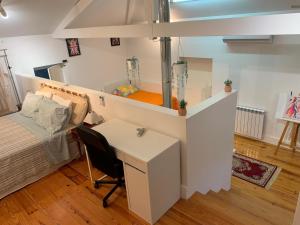 a room with a bed and a desk and a bed and a desk at Encanto Casa com Spa Jacuzzi Open Space Castelo Branco in Tinalhas