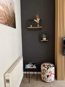 a room with a black wall with a table and a stool at Place2be in Ostend