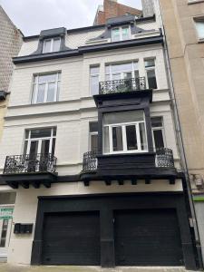 a white house with two garage doors in front of it at Place2be in Ostend
