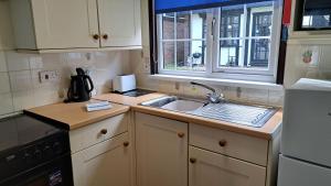a small kitchen with a sink and a window at 15 Tudor Court, Tolroy Manor in Hayle