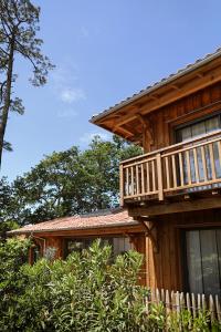 una casa in legno con balcone sul lato di CLUQUE- Maisons de Vacances a Capbreton