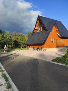 a large wooden house with a black roof at Wood Fairy 2 in Korenica