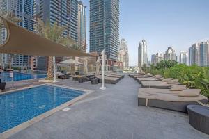 un hotel con piscina y una hilera de camas en FIRST CLASS 1BR Amazing Marina Views, en Dubái