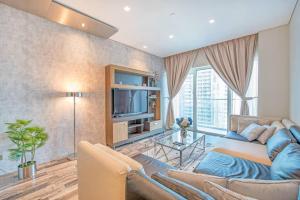Una sala de estar con un sofá y un televisor. en FIRST CLASS 1BR Amazing Marina Views, en Dubái