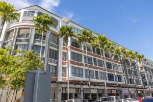 an apartment building with palm trees in front of it at Miri Times Square Serviced Apartment in Miri