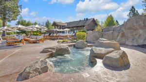 una piscina con rocas en un patio trasero con una casa en Caldera Cabin 6, en Sunriver