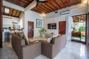 a living room with two couches and a kitchen at Villa Simara in Seminyak