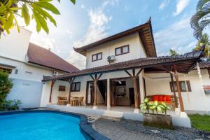 an exterior view of a house with a swimming pool at Villa Simara in Seminyak