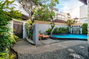 a backyard with a swimming pool and a house at Villa Simara in Seminyak