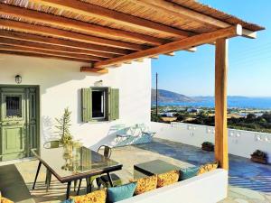 patio ze szklanym stołem i krzesłami na balkonie w obiekcie The old barn, Naousa Paros w mieście Nausa