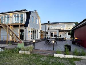 a house with a deck with a table and chairs at Villa Sharevik in Hörvik