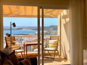 a room with a balcony with a view of the ocean at Amazing Ocean View Apartment in Poris de Abona