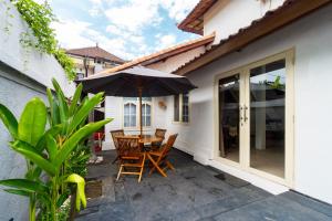 a patio with a table and chairs and an umbrella at Villa Putri Mila in Seminyak