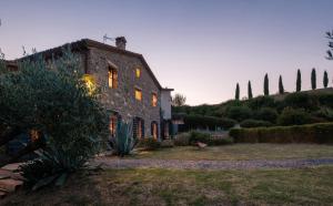 a large stone building with the sun shining on it at Podere San Pasquale in Castiglione dʼOrcia