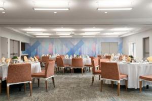 a dining room with tables and chairs and a room with at Hilton Garden Inn Kennett Square in Kennett Square