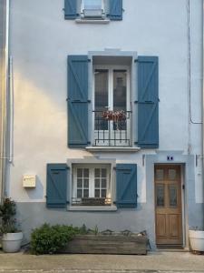 a building with blue shutters and a window at La maison de Tedone in Arles-sur-Tech