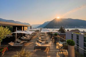 a deck with chairs and umbrellas on a building at Hilton Lake Como in Como