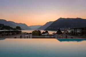 a view of the lake from a hotel swimming pool at sunset at Hilton Lake Como in Como