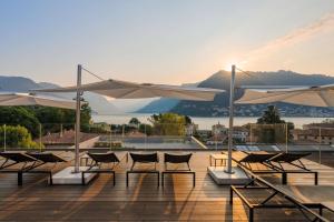 a group of chairs and umbrellas on a deck at Hilton Lake Como in Como