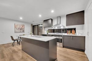a kitchen with a large island in the middle at Scott House in Truganina +5 photos