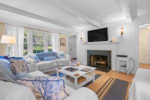 Una sala de estar con dos sofás y una chimenea. en 13 Monomoy Circle Chatham Cape Cod - - BreakAway, en Chatham
