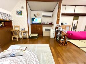 a living room with a bed and a pink couch at Sakura Bloom Separate House in Tokyo