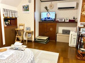 a living room with a bed and a television at Sakura Bloom Separate House in Tokyo