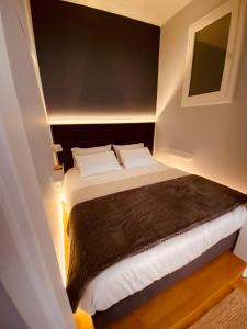 une petite chambre avec un lit avec des oreillers blancs dans l'établissement Athina's Nest, à Athènes