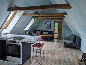 a kitchen with a stove and a living room at Lejlighed ved skov in Græsted
